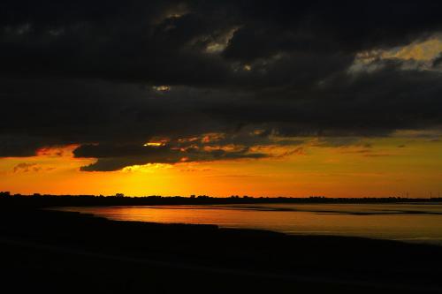 a sunset over a body of water with clouds at Komfortable Apartments in der Villa Eule in Varel