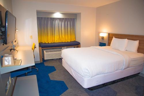 a hotel room with a large bed and a window at Microtel Inn & Suites by Wyndham Daphne in Daphne