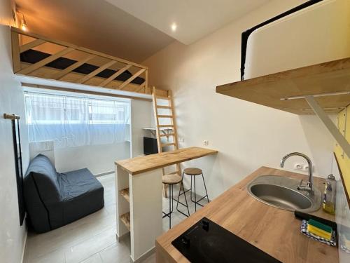 Il comprend une petite cuisine avec un évier et des lits superposés. dans l'établissement Cosy Studio avec Mezzanine proche ville, à Nice