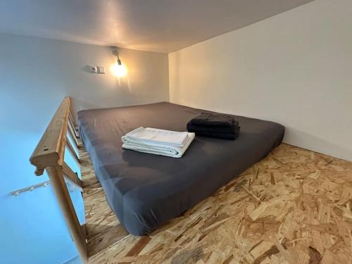 une chambre avec un lit avec des serviettes dessus dans l'établissement Cosy Studio avec Mezzanine proche ville, à Nice