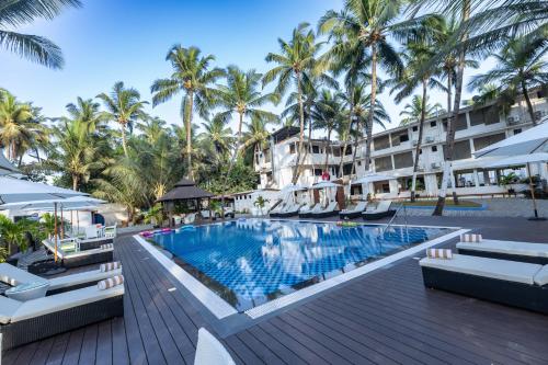 an infinity pool at a resort with palm trees at The Woodside Inn in Benaulim