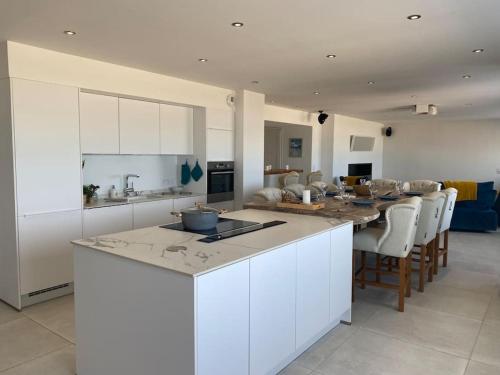 une cuisine et un salon avec une table et des chaises dans l'établissement La Plage, à Donville-les-Bains