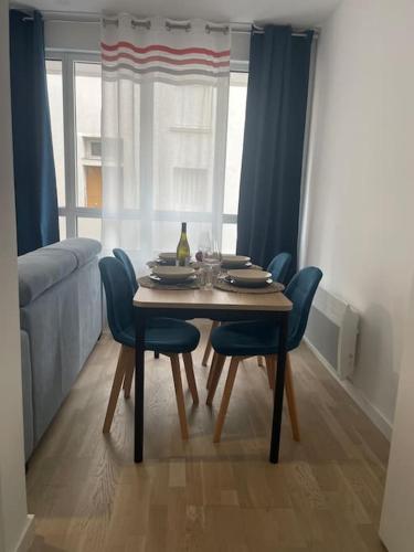 - une table à manger avec des chaises et une bouteille de vin dans l'établissement Chez Hélène T2 à Nantes Centre, à Nantes