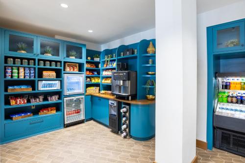 a kitchen with blue cabinets and a refrigerator at DoubleTree by Hilton Houston Medical Center Hotel & Suites in Houston