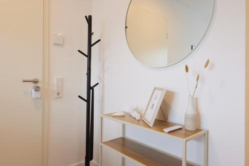 a bathroom with a mirror and a table with a shelf at HomeME 1 I zentral I NETFLIX I Küche I Parkplatz I kliniknah in Bad Oeynhausen