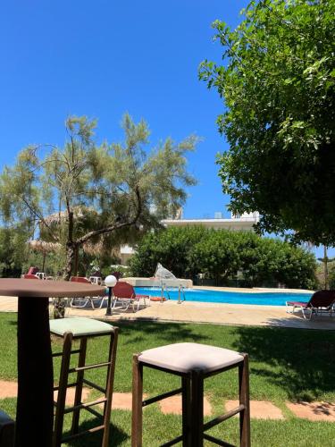 a table and two chairs next to a pool at Portokali Apartments in Hersonissos