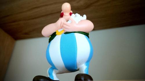 a toy penguin is sitting on top of a figurine at Fab House - Les Maisons Fabuleuses in Senlis