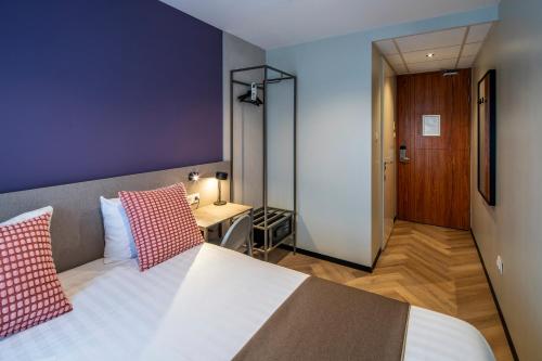 a bedroom with a bed with red and white pillows at Hotel Fogo Amsterdam in Amsterdam