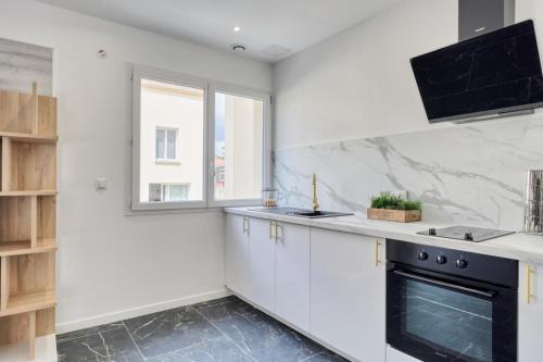 a kitchen with white cabinets and a black oven at Studio 1 in Coubron