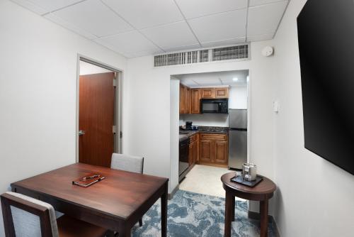 a dining room with a table and a kitchen at DoubleTree by Hilton Houston Medical Center Hotel & Suites in Houston