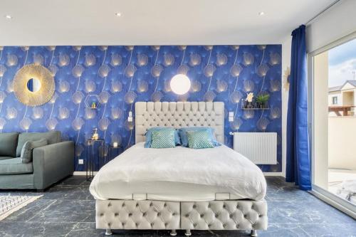 a bedroom with a bed and a blue wall at Studio 1 in Coubron