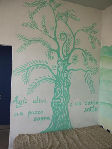 a mural of a tree on a wall at Fòndaco Scandicci in Scandicci