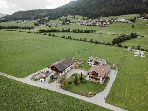 an aerial view of a house in a green field at Pichlerhof in Valle Di Casies