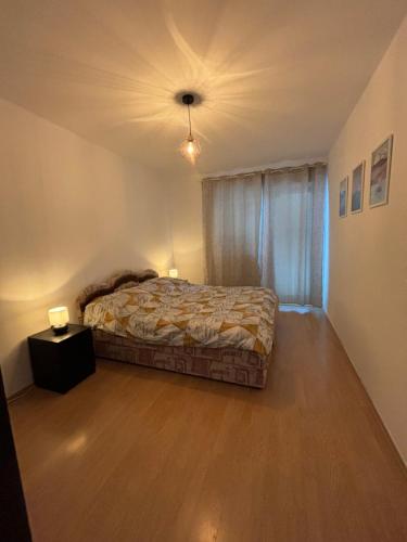 a bedroom with a bed and a night stand with two lamps at Apartman Zlatija in Bajina Bašta