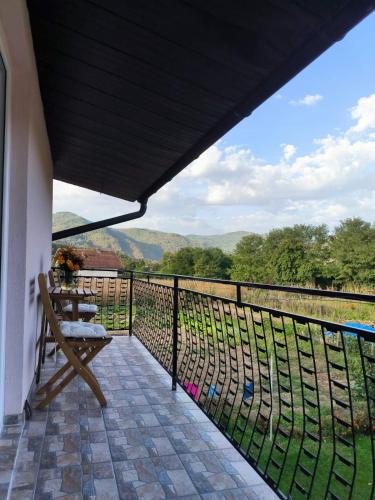 a balcony with a bench and a view of the mountains at Apartman Zlatija in Bajina Bašta