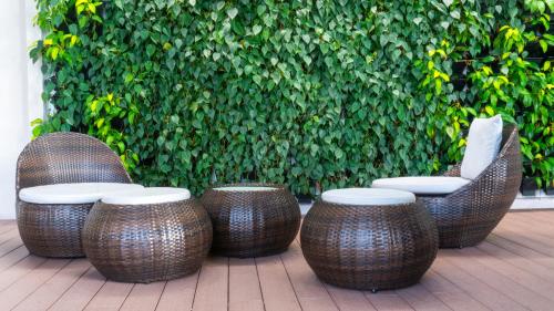 a group of wicker chairs and stools on a patio at MOONWAY SUITES At EATON KLCC in Kuala Lumpur