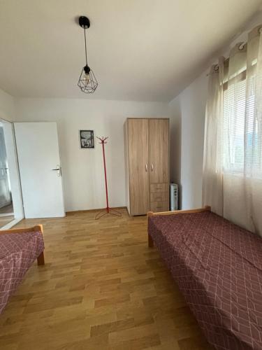a bedroom with two beds and a wooden floor at Apartman Zlatija in Bajina Bašta
