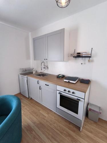 a kitchen with white cabinets and a sink and a stove at Apartman Zlatija in Bajina Bašta