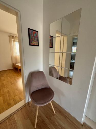 a chair sitting in a room with a mirror at Apartman Zlatija in Bajina Bašta