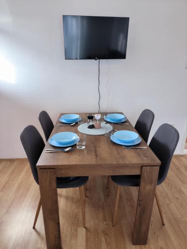 a wooden dining room table with chairs and a television at Apartman Zlatija in Bajina Bašta