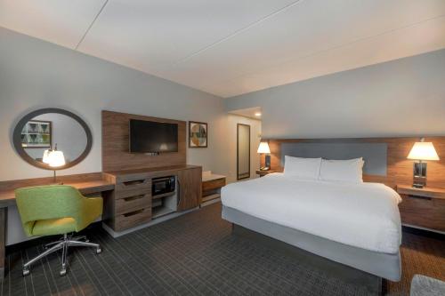 a hotel room with a bed and a desk and a television at Hampton Inn & Suites Burlington in Burlington