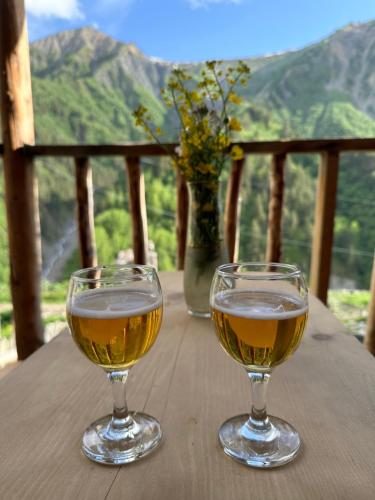 two glasses of wine sitting on a wooden table at Tamazi guest house in Adishi