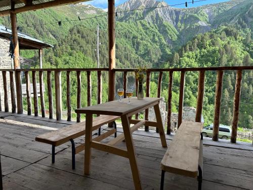 a wooden table and bench on a porch with a view at Tamazi guest house in Adishi