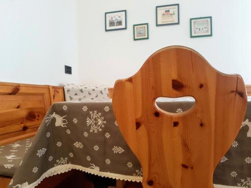 a wooden chair with a blanket on top of it at Casa Dorigoni Molveno in Molveno