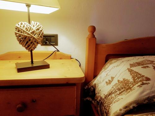 a lamp on a night stand next to a bed at Casa Dorigoni Molveno in Molveno