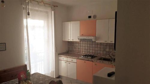 a kitchen with orange and white cabinets and a window at Casa Dorigoni Molveno in Molveno