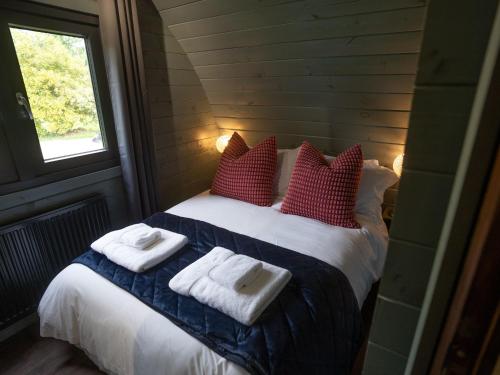 a bedroom with a bed with towels on it at Foxes Den in South Cerney