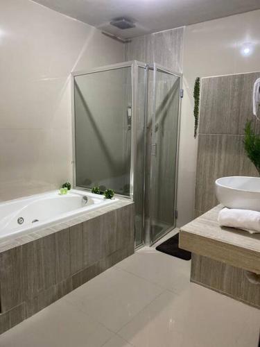 a bathroom with a shower and a tub and a sink at Moderna Casa con Jacuzzi Hidromasaje in Los Mochis