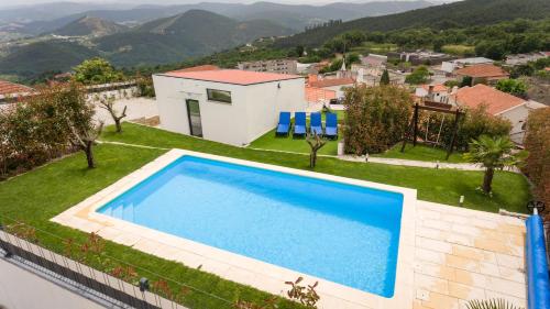 a villa with a swimming pool on a hill at Casa Alto da Massada in Canelas