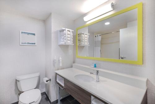 a bathroom with a sink and a toilet and a mirror at Hampton Inn & Suites Burlington in Burlington