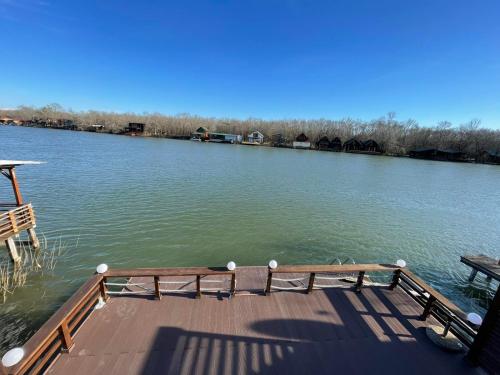 a wooden dock on a lake with a boat at Kaseta in Ulcinj