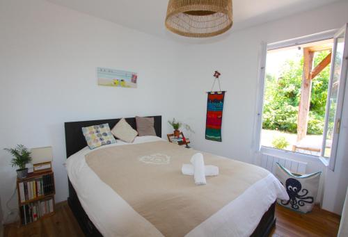 une chambre avec un grand lit avec une grande fenêtre dans l'établissement Maison 4 chambres et grand jardin, à La Teste-de-Buch