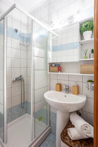 a bathroom with a sink and a shower at Cute apartment 20m from beach in Nea Potidaea