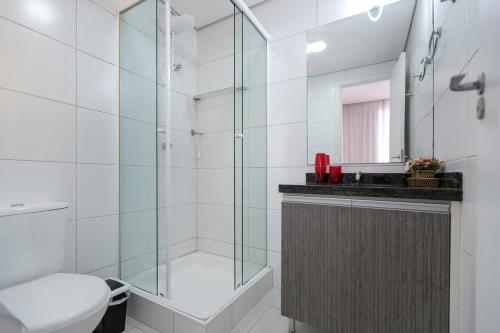 a bathroom with a glass shower and a toilet at Studio Espaço Moderno in Curitiba