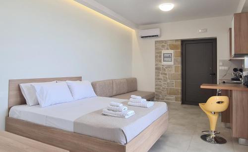 a bedroom with a bed with towels on it at Studios Rosmari in Áyioi Pándes