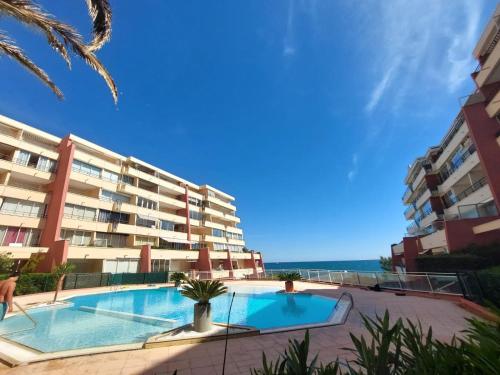 une piscine devant un grand immeuble d'appartements dans l'établissement T2 sur zone pietonne, a quelques pas des plages, à Sète