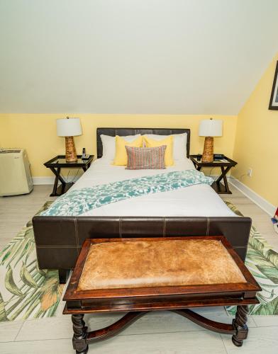 a bedroom with a bed and a coffee table at Water's Edge Inn - Adults Only in Folly Beach
