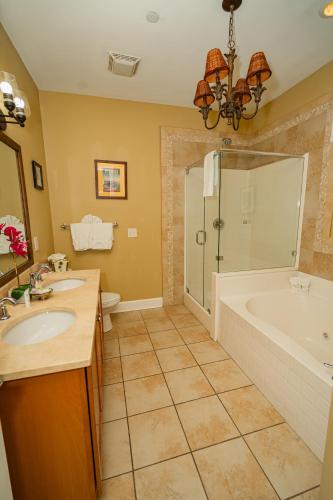 a bathroom with a tub and a sink and a shower at Water's Edge Inn - Adults Only in Folly Beach