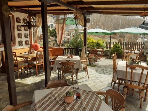 an outdoor restaurant with tables and chairs and umbrellas at Restuarant-Apartments T'ga za jug Lazaropole in Lazaropole