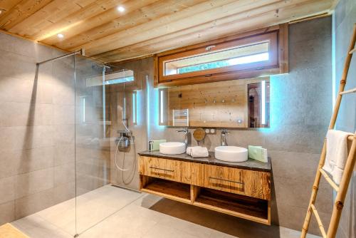 une salle de bain avec deux lavabos et une douche dans l'établissement CHALET LES EVES, à Morzine