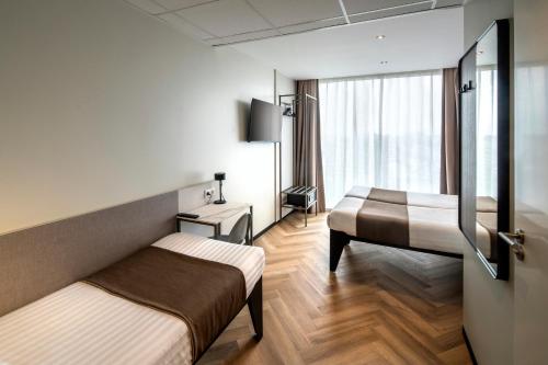 a hotel room with two beds and a window at Hotel Fogo Amsterdam in Amsterdam