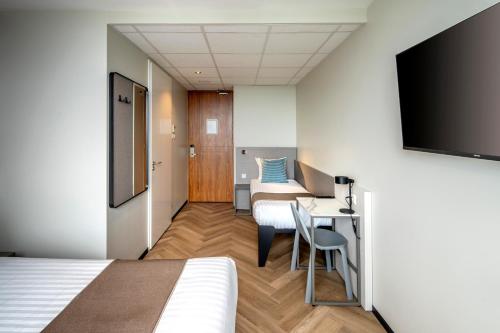 a hotel room with two beds and a tv at Hotel Fogo Amsterdam in Amsterdam