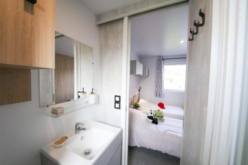 a small child sitting on a bed in a bathroom at Camping Heino in Heino