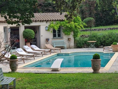 une piscine avec des chaises longues à côté d'une maison dans l'établissement Magnifique villa à Montaud, à Montaud