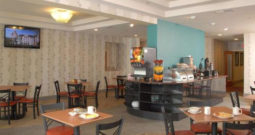 アトランタにあるベストウエスタン プラス アトランタエアポート イーストのテーブルと椅子、冷蔵庫付きのレストラン