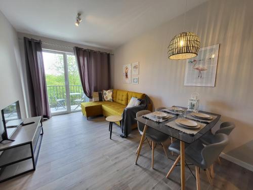 a living room with a table and a yellow couch at NordApart Słoneczna Dolina 24 in Jastrzębia Góra
